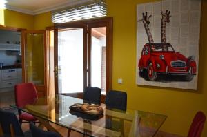 Sant Cebrià de Vallalta的住宿－Sea view, Wonderful pool, Nature, Peaceful，一间用餐室,配有玻璃桌和墙上的红色汽车