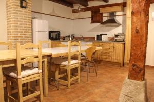 een keuken met een tafel en stoelen en een koelkast bij CASA RURAL LAS BODEGAS in Valbuena de Duero