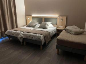 2 Betten in einem Hotelzimmer mit 2 Betten in der Unterkunft Hôtel MAAS in Montigny-le-Roi
