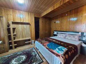 une chambre avec un lit dans une pièce en bois dans l'établissement Bitta Inn homestay, à Darjeeling