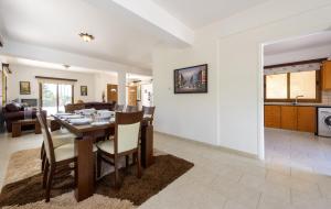 a dining room and living room with a table and chairs at Villa Sam in Ayia Napa