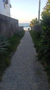 un camino de piedra que conduce a la playa en Ilha do Coral Residence, en Florianópolis
