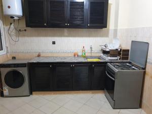 uma cozinha com um fogão e uma máquina de lavar louça em Appartement al fadl em Marrakech