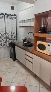 cocina con microondas en la encimera en Ilha do Coral Residence, en Florianópolis