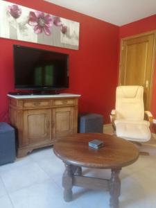 a living room with a flat screen tv and a coffee table at Gite Appartement "Le bel étage" jacuzzi piscine 6 Personnes in Godinne