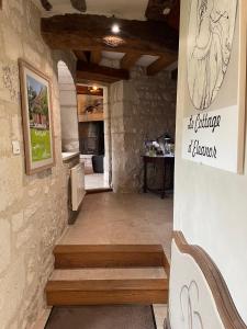a room with a stone wall and stairs in a building at Le Cottage d'Eleanor gîte de charme avec spa Jacuzzi privé in Marçay