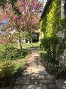 une passerelle en pierre à côté d'un bâtiment avec un arbre dans l'établissement Le Cottage d'Eleanor gîte de charme avec spa Jacuzzi privé, à Marçay