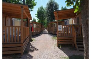 a row of wooden cabins in a row at Club del Sole Rimini Family Resort in Rimini