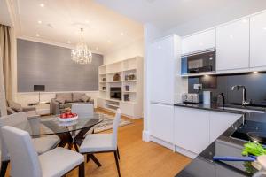 a kitchen and living room with a table and chairs at Chesham Court Knightsbridge in London
