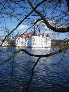 a large white building in the middle of a body of water at Ferienwohnung Storchennest in Hürup