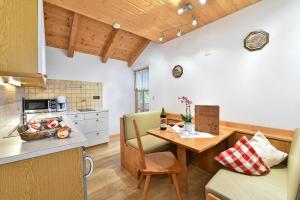 una cucina e una sala da pranzo con tavolo e bancone di Birkenhof - Wohnung Ortler a Sluderno