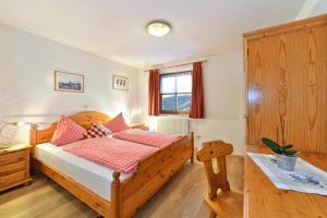 una camera con letto in legno e cuscini rossi di Birkenhof - Wohnung Ortler a Sluderno