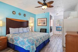 een slaapkamer met een bed en een plafondventilator bij Malibu Resort Motel in St Pete Beach