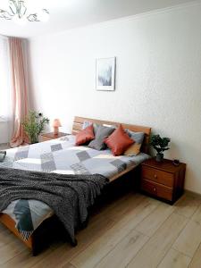 um quarto com uma cama grande com almofadas em Nice2GreetYou em Chernivtsi