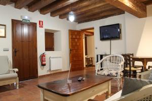 - un salon avec une télévision, une table et des chaises dans l'établissement CASA RURAL LAS BODEGAS, à Valbuena de Duero