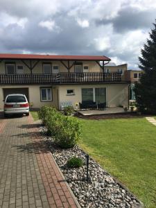 ein Haus mit einem davor geparkten Auto in der Unterkunft Pokoje gościnne Antonia in Władysławowo