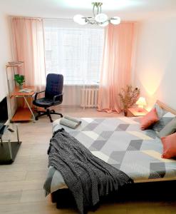 um quarto com uma cama, uma secretária e uma cadeira em Nice2GreetYou em Chernivtsi