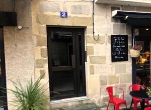 een deur naar een restaurant met rode stoelen en een tafel bij Charming one bedroom apartment in Brive center in Brive-la-Gaillarde