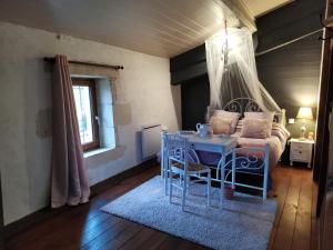 a room with a bed and a table and a couch at Warm 2 bedroom stone house with garden - Dodo et Tartine in Saint-Sigismond