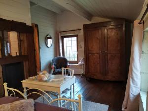 a person sitting at a table in a room at Warm 2 bedroom stone house with garden - Dodo et Tartine in Saint-Sigismond