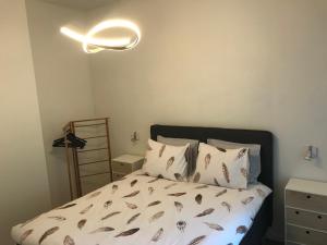 een slaapkamer met een bed met kussens en een licht bij Quiet and cosy apartment near the city center of Diest in Diest