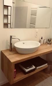 lavabo blanco en una encimera de madera con espejo en Quiet and cosy apartment near the city center of Diest en Diest