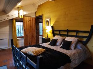 a bedroom with a large bed with a wooden wall at Warm 2 bedroom stone house with garden - Dodo et Tartine in Saint-Sigismond