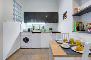 uma cozinha com uma mesa e uma máquina de lavar roupa em Premium Studio Szervita Square em Budapeste