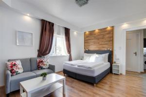 um quarto de hotel com uma cama e um sofá em Premium Studio Szervita Square em Budapeste