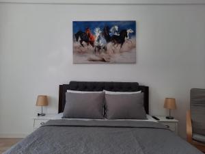 een slaapkamer met een bed met een schilderij aan de muur bij Luxury City Center Apartment – Garofita Romana in Boekarest