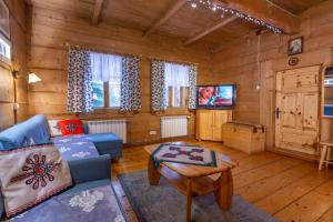a living room with a blue couch and a tv at Stara Chata in Zakopane