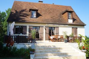 una casa con patio, tavolo e sedie di Le Coze a Saint-Martial-de-Nabirat