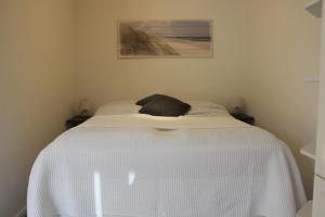 een wit bed met een deken erop in een kamer bij Appartement 660 Erik in Flensburg