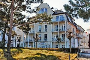 a large white building with trees in front of it at Nixe - Villa Helene mit Meerblick in Top Lage in Binz