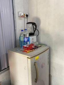 einen kleinen Kühlschrank mit Wasserflaschen darüber in der Unterkunft CabinStay Cikgu Sungai Batu Besi in Sungai Petani