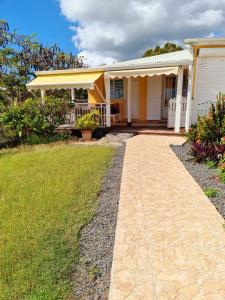 a house with a walkway in front of a yard at LOUE F3 VUE SUR MER DANS PROPRIETE PRIVEE in Sainte-Anne