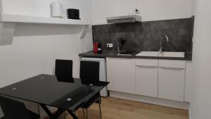 uma cozinha com um lavatório e uma mesa com cadeiras em Appartement 6 - T2 60m2 - Standing, moderne et tout équipé - Carmes-Renforts , Toulouse em Toulouse