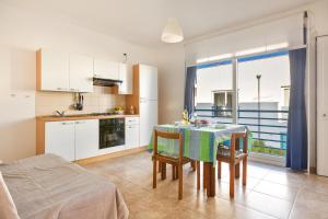 a kitchen and dining room with a table and chairs at Appartamento Cristallo by BarbarHouse in Torre Lapillo