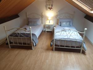 two twin beds in a room with a attic at Les Gages in Brécé +43 photos