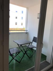 - une table et deux chaises dans une chambre avec fenêtre dans l'établissement Le Zambeze - Calme et spacieux - parking couvert, à Saint-Herblain