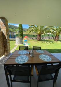 einen Holztisch und Stühle mit Blick auf den Hof in der Unterkunft Apartamentos El Pradón in Cudillero