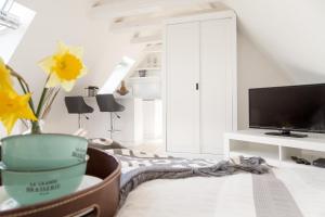 a white living room with a tv and a flower at Ferienwohnung - Tessa in Tinnum