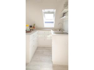 a white kitchen with a sink and a window at Ferienwohnung - Tessa in Tinnum +10 photos