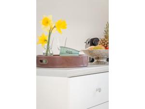 a shelf with a vase of flowers and a bowl of fruit at Ferienwohnung - Tessa in Tinnum