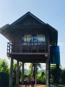 una casa en el árbol con balcón en la parte superior en Sigiriya Paddy Field Hut, en Sigiriya