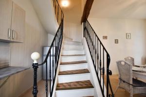 una escalera en una casa con paredes blancas y suelo de madera en L'Oustau - ruelle bucolique en Arlés