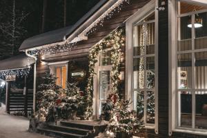 una casa decorada con luces de Navidad y árboles de Navidad en Tsarstvo Korolevstvo, en Roshchino