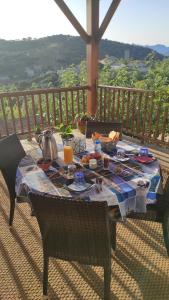 una mesa con comida y bebida en el balcón en Alegria, en Arbellara