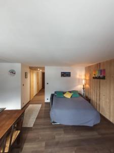 1 dormitorio con 1 cama y suelo de madera en La Chaine du Mont-blanc en Chamonix-Mont-Blanc