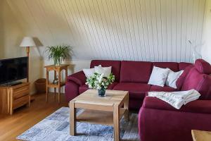 a living room with a purple couch and a table at Haus am Bodden 03 in Ahrenshoop